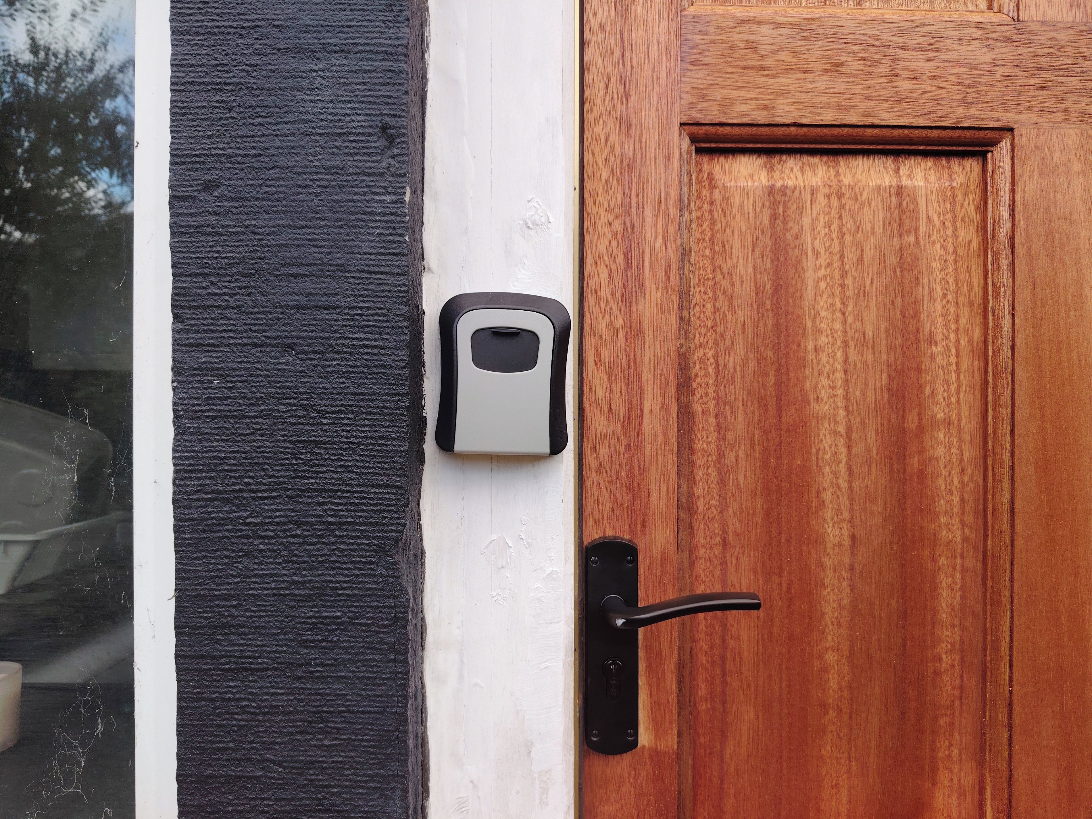 A door with a black handle and a white doorbell button.