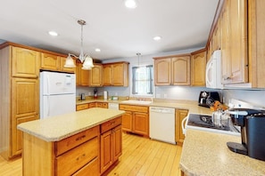 A kitchen with wooden cabinets, a granite countertop, a dishwasher, and a coffee maker. - 3BR Mountainview Dog Friendly - Balcony - Washer Dryer (Gilford)