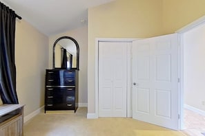 A room with a black dresser, a white door, and a mirror. - Lake view 2BR with dock & deck, walk to the beach (Moultonborough)