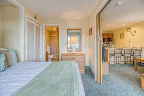 Ein Hotelzimmer mit einem Bett, einem Schminktisch, einem Schreibtisch mit Stühlen und einer Küchenzeile.