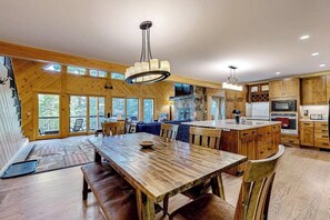 Una cocina amplia con armarios de madera, una isla central y un comedor con bancos.