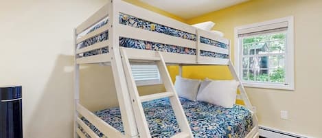 A bunk bed with a ladder, a window with a view, and a heater.