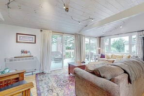 Een ruime woonkamer met een grote bank, een salontafel en een kamerbreed tapijt.