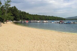 A sandy beach with boats docked along the water's edge. - 3BR Fully renovated, dog friendly home (Meredith)