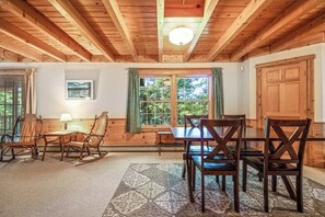 A wooden interior with a dining table, chairs, and a window with curtains. - Charming 3BR Lakefront - Dock - Deck (Center Harbor)