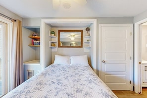 A bedroom with a bed, a ceiling fan, a mirror, and built-in shelving. - 1BR with pool & tennis, walk to Lake Winnipesaukee (Gilford)