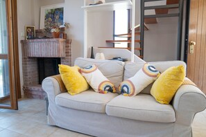 A living room with a sofa, a fireplace, and a door. - Halkidiki Kassandra villa 3P Peace & Beautiful Sea (Agia Paraskevi)