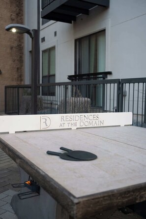A table with a sign indicating 'Residences at the Domain' and a paddle on it. - The Nomad / Domain Rolex Building (Austin)