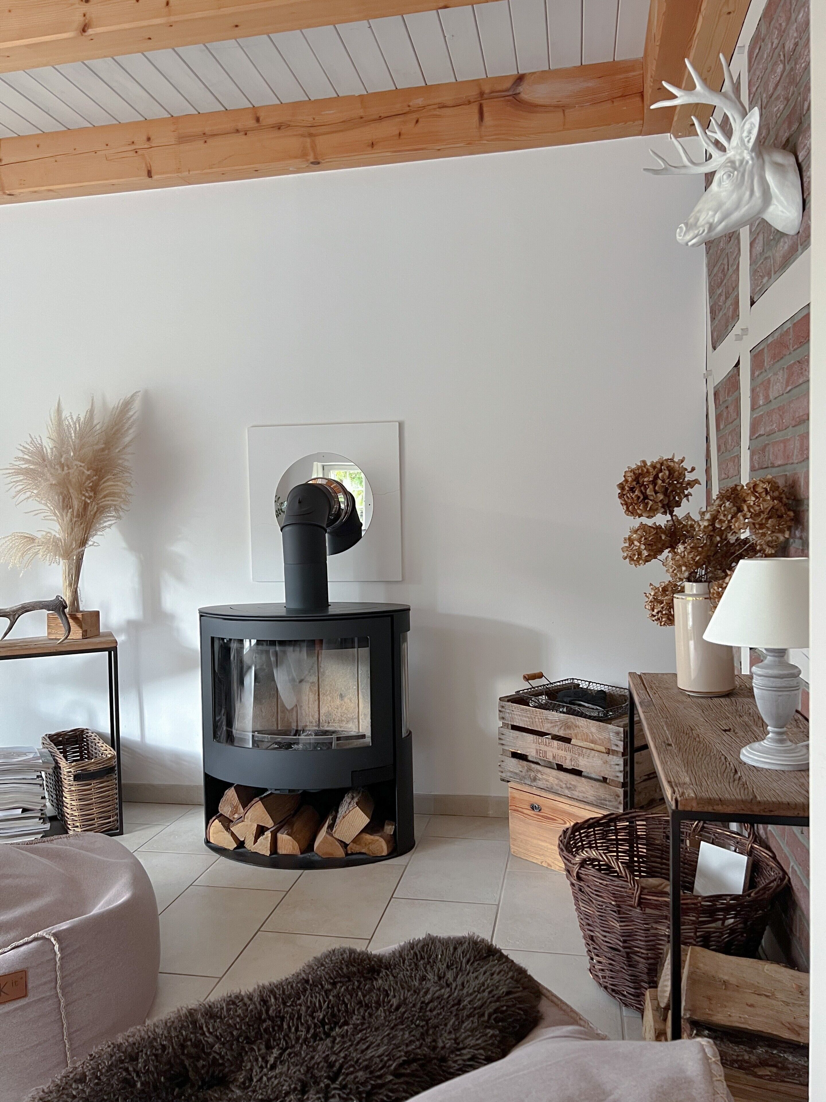 Un salon chaleureux avec un poêle à bois, un miroir et un décor rustique.