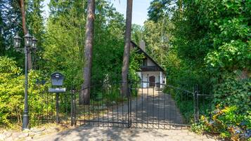 A gated entrance to a building surrounded by trees.