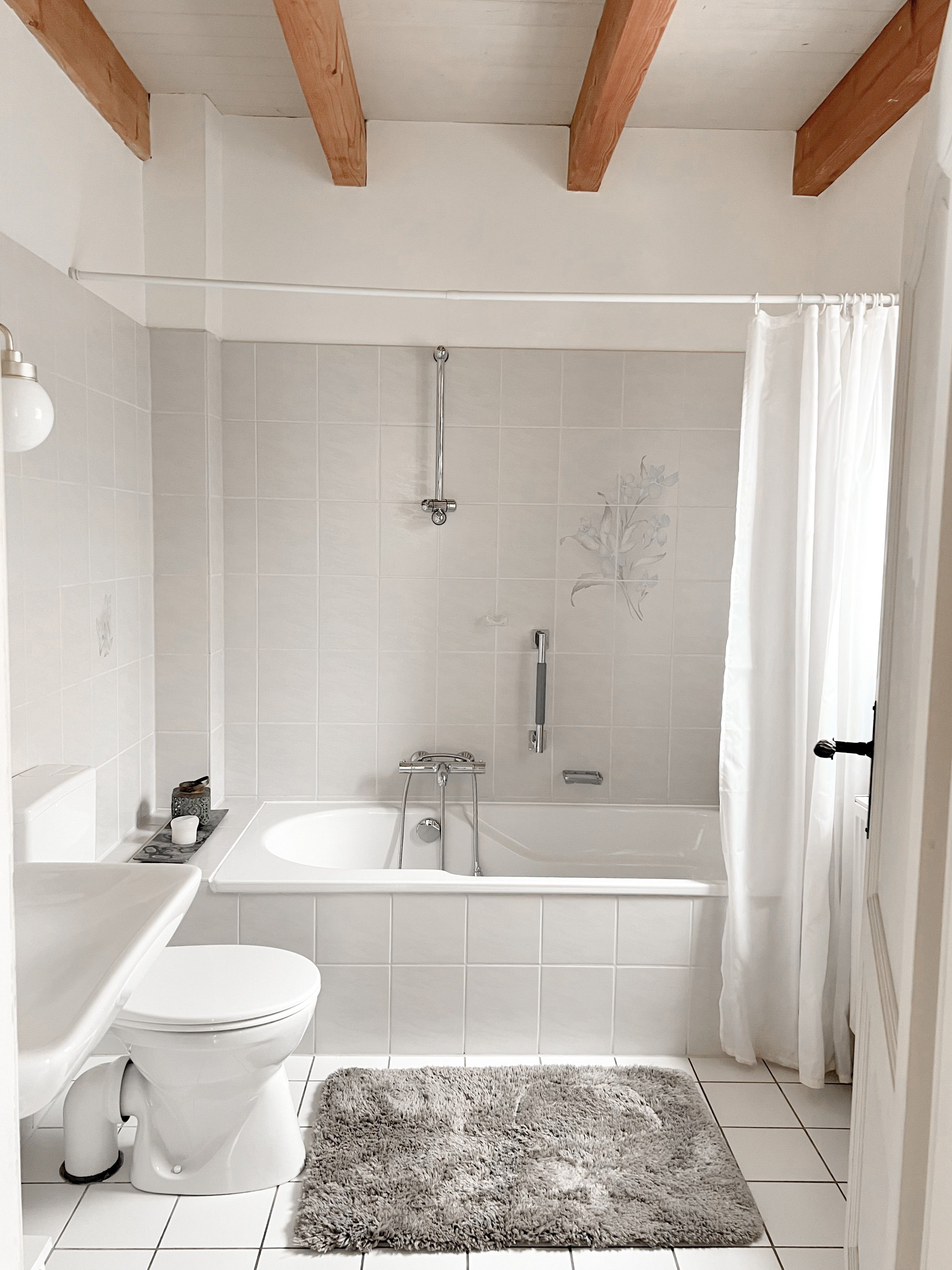 Ein Badezimmer mit Badewanne, Toilette und Duschbereich.