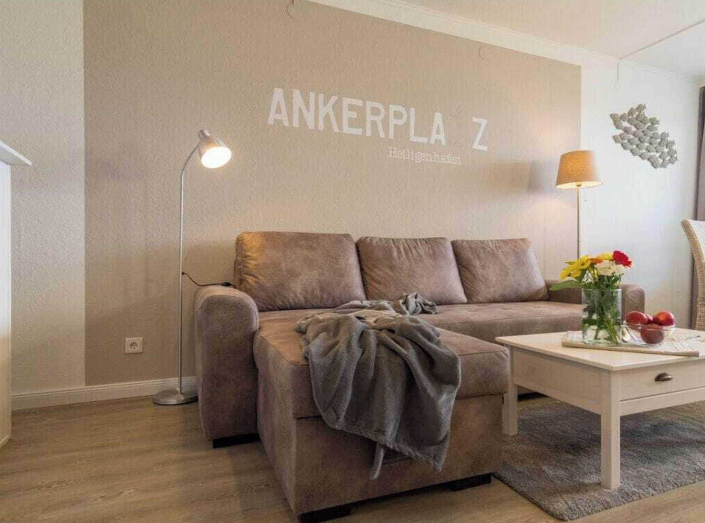 Una sala de estar moderna con un sofá, una mesa de centro, una lámpara y una pared con el texto 'ANKERPLA Z'.