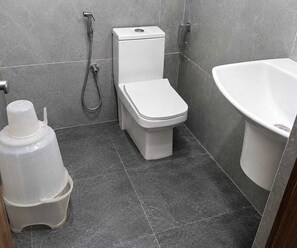 A bathroom with a toilet, a shower, and a sink. - Classic Hotel Stay Comfort (Hyderabad)