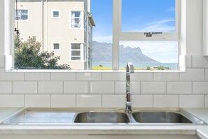 Una cocina con vista a una montaña y un edificio.