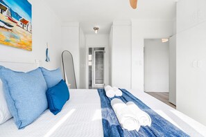 A hotel room with a bed, a shower, and a view of the sea. - Annies Haven at Greenways Golf Estate (Cape Town)