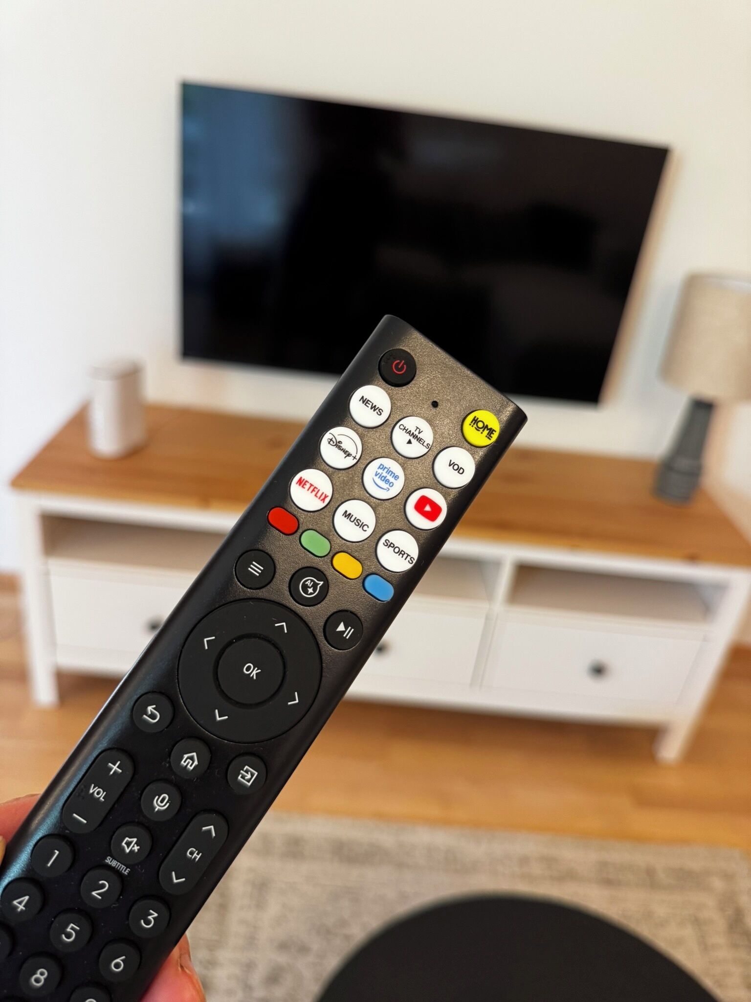 A remote control with various buttons including TV, Netflix, and Prime Video.