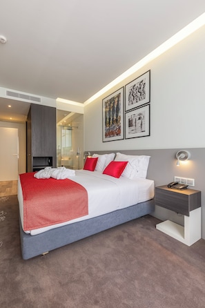A modern hotel room with a large bed, a bedside table with a lamp, and artwork on the wall. - Elegant Beach Villa – Spacious, Private & Relaxing (Maputo)