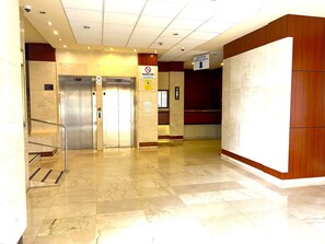 A lobby with two elevators, a no-smoking sign, and a directional sign for 'Ascensor Montacarga.' - Aloha Playa Deluxe: Wi-Fi, Swimming Pools, and Parking (Benalmádena)
