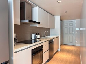 A modern kitchen with a dishwasher, oven, and a toaster on the counter. - Modern 1BR Residence Near Galataport (Istanbul)