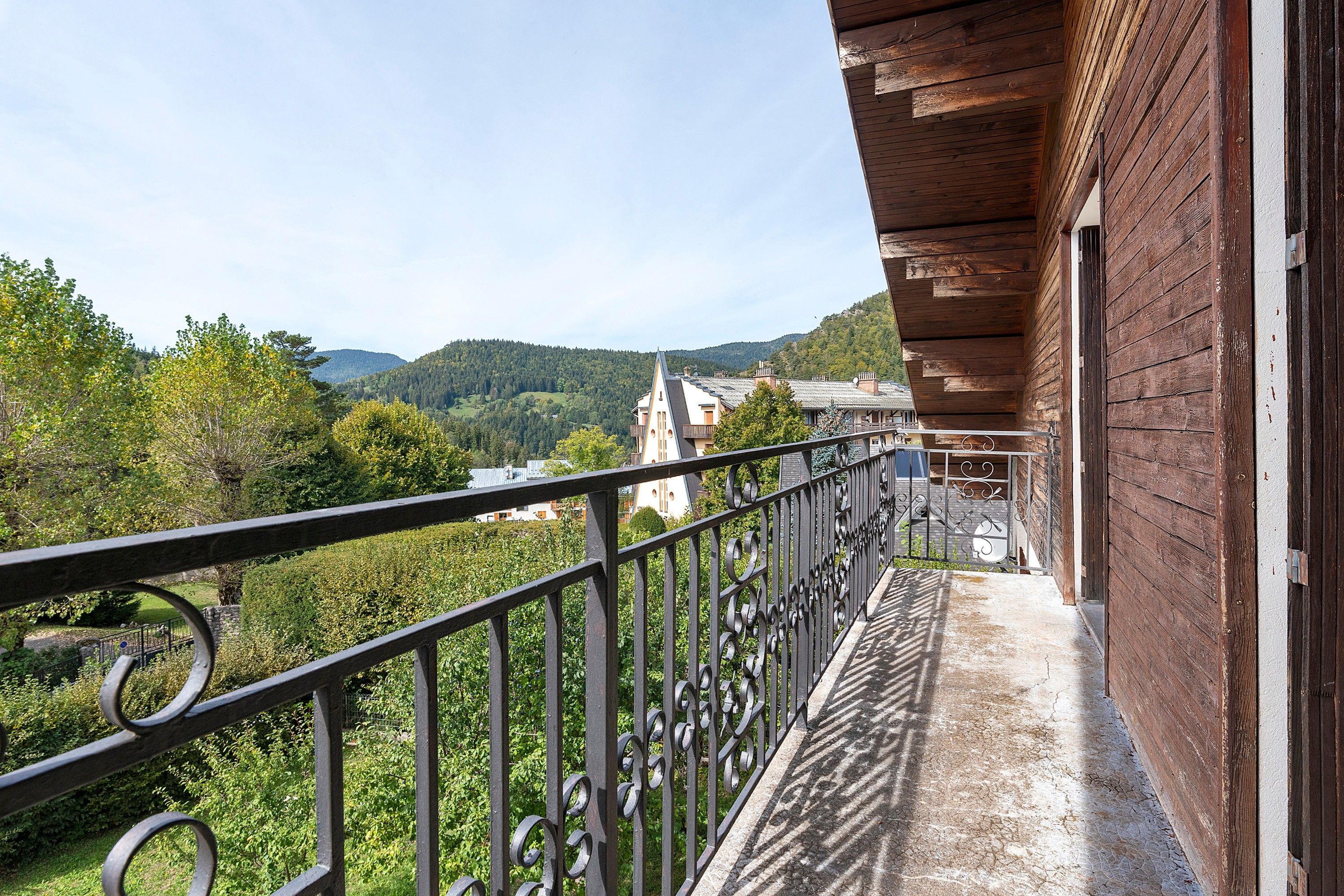 A balcony with a wrought iron railing overlooking a mountainous landscape.
