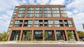 A multi-story building with large windows and a brick facade. - Modern Condo Getaway with Free Parking (Toronto)