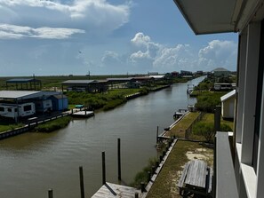 A river with docks, a boat, and buildings along the banks. - Tranquil 1-bedroom bungalow with AC in Bolivar Peninsula (Bolivar Peninsula)