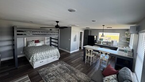 A compact living space with a bunk bed, kitchenette, and a dining area. - Tranquil 1-bedroom bungalow with AC in Bolivar Peninsula (Bolivar Peninsula)