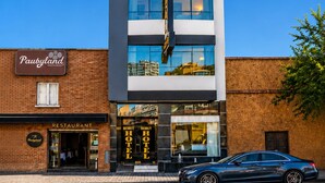 Ein Hotel mit mehreren Etagen, einer markanten Schilderung und einem daran angrenzenden Restaurant.