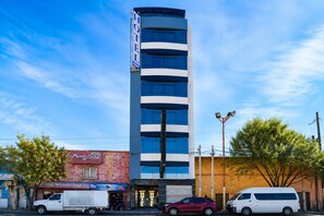 A hotel with a modern design, featuring a vertical orientation and a prominent sign.