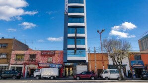 Un hotel de diseño moderno, con un llamativo letrero vertical y varias ventanas.