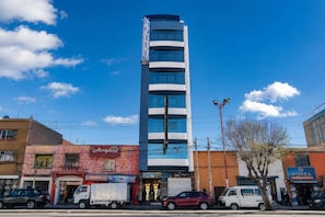Un hotel de diseño moderno, con un llamativo letrero vertical y varias ventanas.
