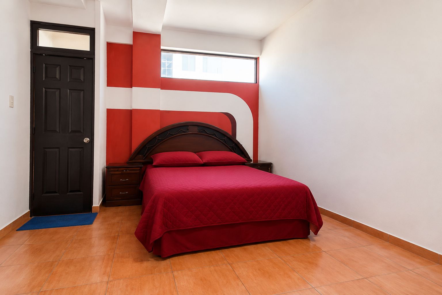 Un dormitorio con cama, mesita de noche, cómoda, puerta y ventana.