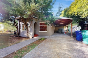 Ein Wohnhaus mit überdachter Veranda, Garage und Auffahrt.