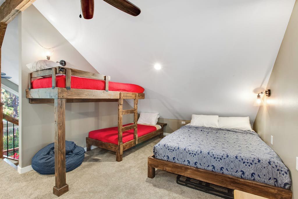 Una habitación con literas, una cama individual y un sillón de pelota.