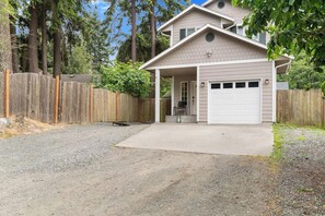 A single-story house with a garage, a gravel driveway, and a wooden fence. - 3 BR home in Port Angeles with private sauna (Port Angeles)
