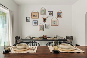 A dining area with a table set for four, framed artwork on the wall, and a bull's head decoration. - 3 BR home in Port Angeles with private sauna (Port Angeles)
