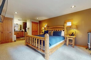 Ein Schlafzimmer mit einem hölzernen Bett, einem Nachttisch, einer Lampe und einem Heizgerät.