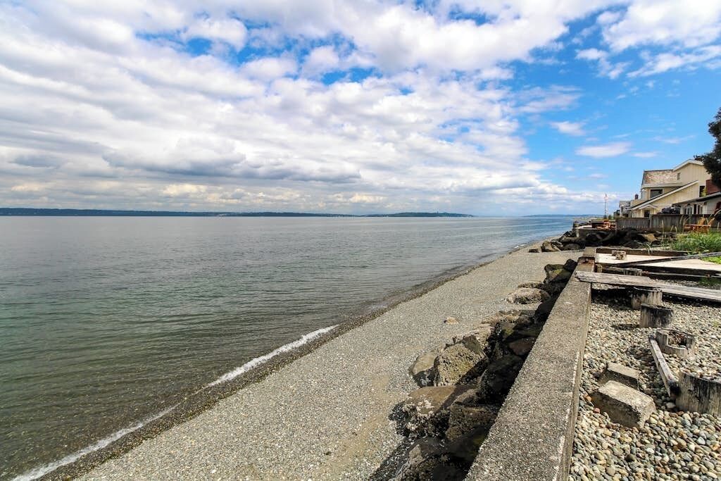 Une plage côtière avec un rivage rocheux et une vue dégagée sur la mer.