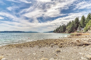 A rocky shoreline with a view of the water and distant land. - 4BR Bayview Dog Friendly - Balcony - Firepit (Brinnon)