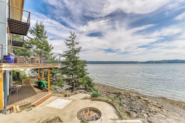 A lakeside property with a deck, a fire pit, and a view of the water. - 4BR Bayview Dog Friendly - Balcony - Firepit (Brinnon)