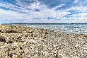 A rocky shoreline with calm water and a clear sky. - 4BR Bayview Dog Friendly - Balcony - Firepit (Brinnon)