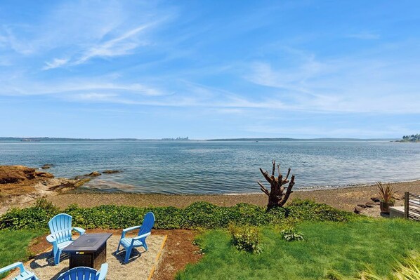 Une terrasse au bord du lac, avec des sièges extérieurs et une vue sur l’eau.