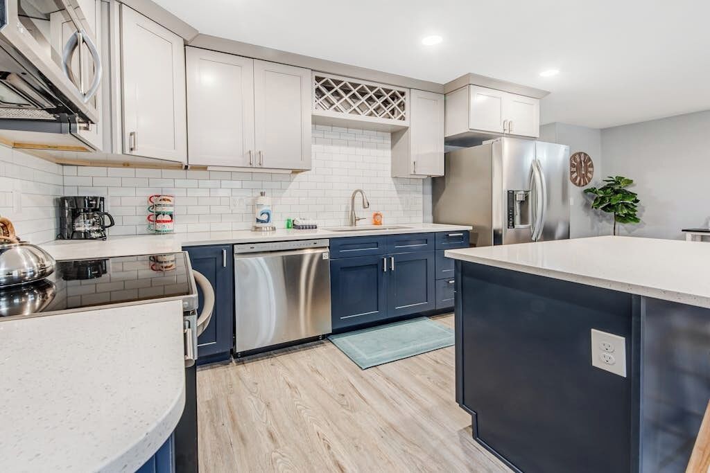 Una cocina moderna con electrodomésticos de acero inoxidable, lavavajillas y refrigerador.