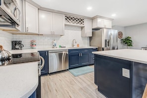 A modern kitchen with stainless steel appliances, a dishwasher, and a refrigerator. - Modern 3BR Dog Friendly - Hot Tub - Patio (Westport)