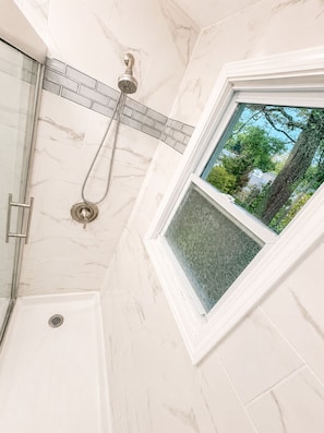 A corner of a bathroom with a shower, a window, and a view of trees. - Modern Cozy Stay Near
Downtown, Blossom & Cuyahoga Valley National Park (Cuyahoga Falls)