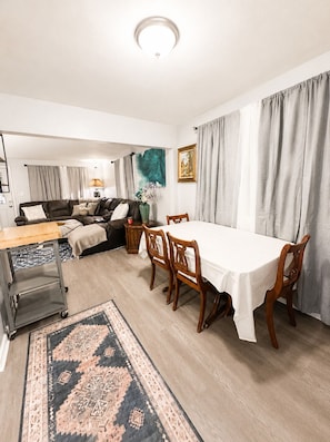 A dining area with a table and chairs, a sofa, a lamp, and a rug. - Modern Cozy Stay Near
Downtown, Blossom & Cuyahoga Valley National Park (Cuyahoga Falls)