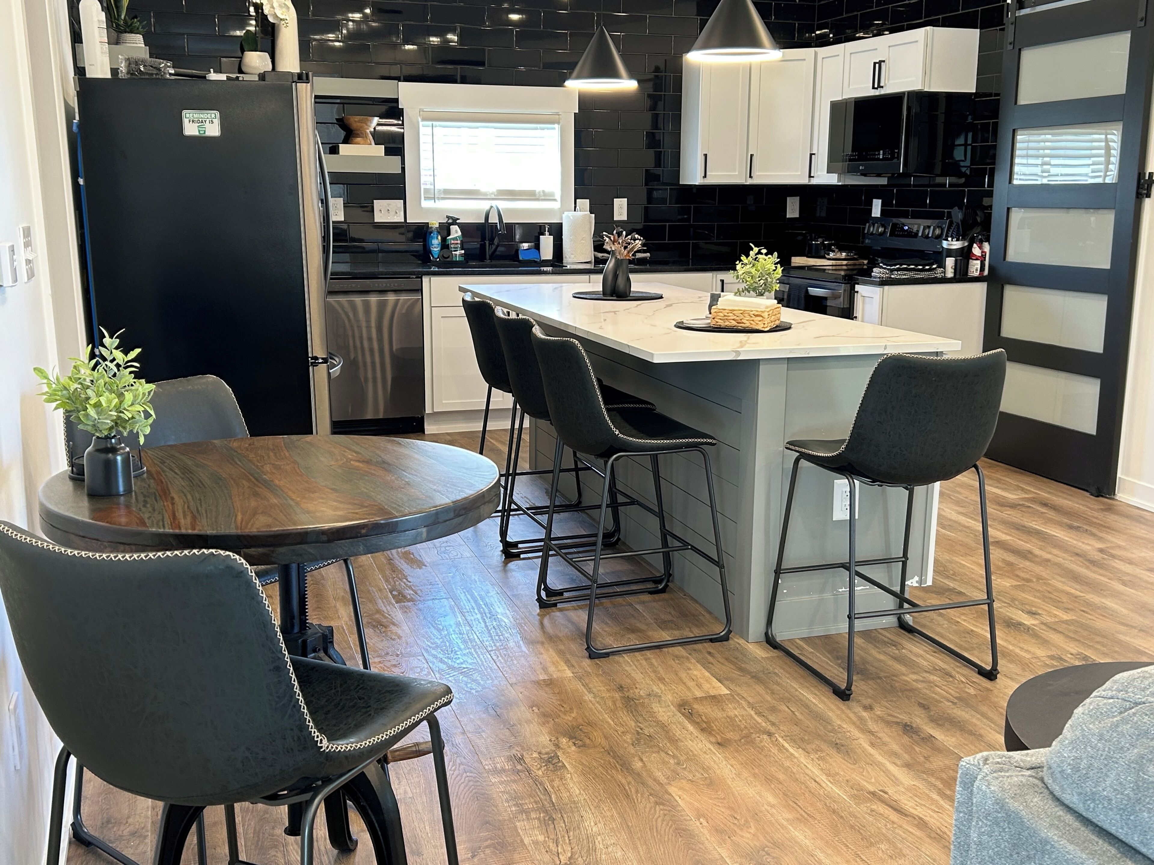 Une cuisine moderne dotée d’un îlot central, de tabourets de bar et d’une table à manger avec des chaises.