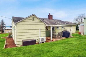 A single-story house with a covered patio area, a chimney, and a small lawn. - 3BR Waterview - Deck - Washer Dryer (Des Moines)