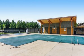 Un edificio con una zona exterior techada, piscina y un espacio cercado.