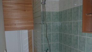 Een badkamer met toilet, bad en douche.